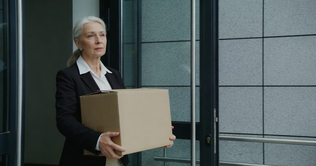 femme de 55 ans sortant d un bureau avec carton