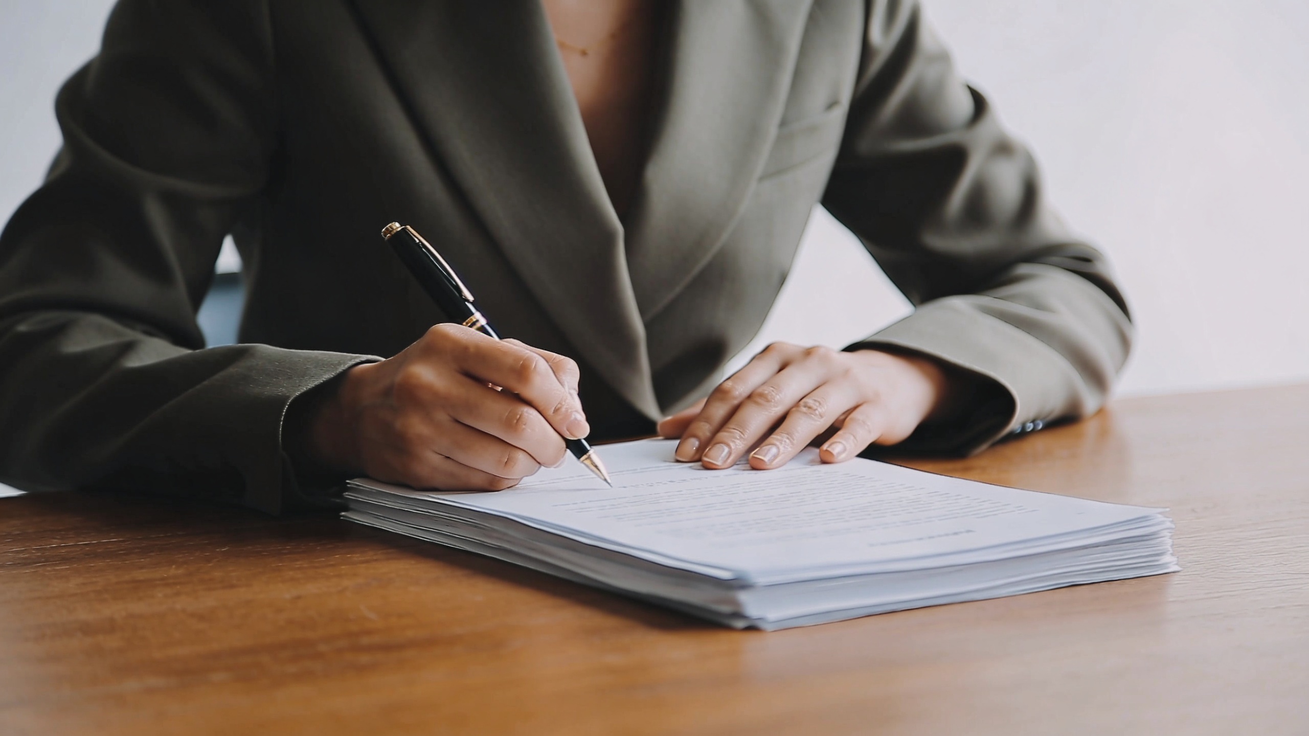 femme assise a un bureau signant des papiers