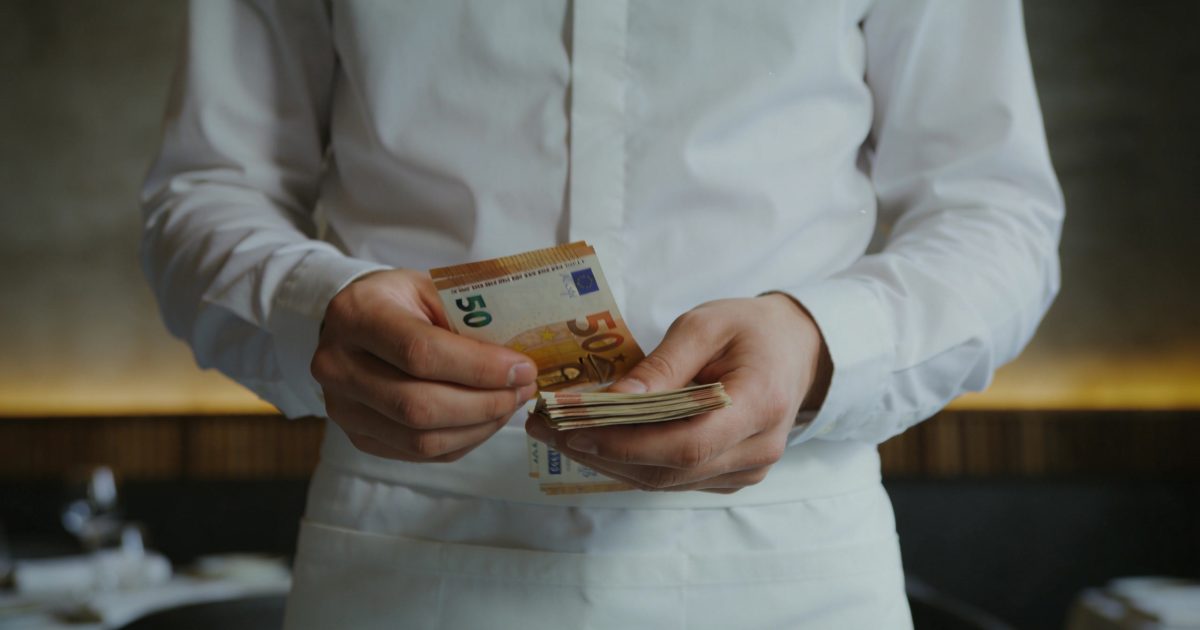 serveur de restaurant luxembourgeois comptant des billets euro