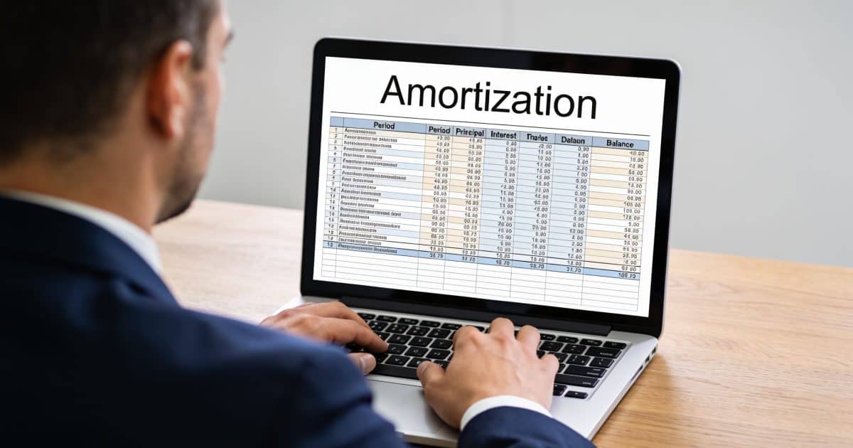 comptable assis devant ordinateur affichant tableau amortissement