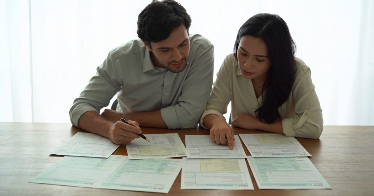 couple assis a table examinant des avis dimpot