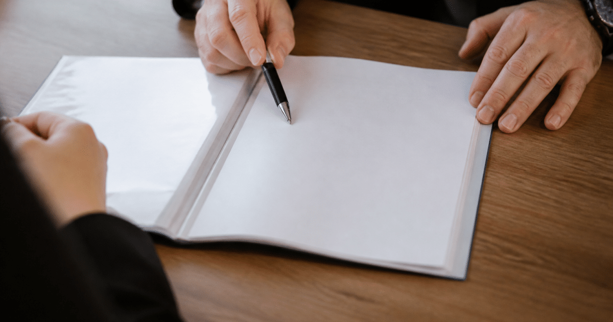 Document d'assurance vie ouvert sur bureau avec stylo pointant vers beneficiaire
