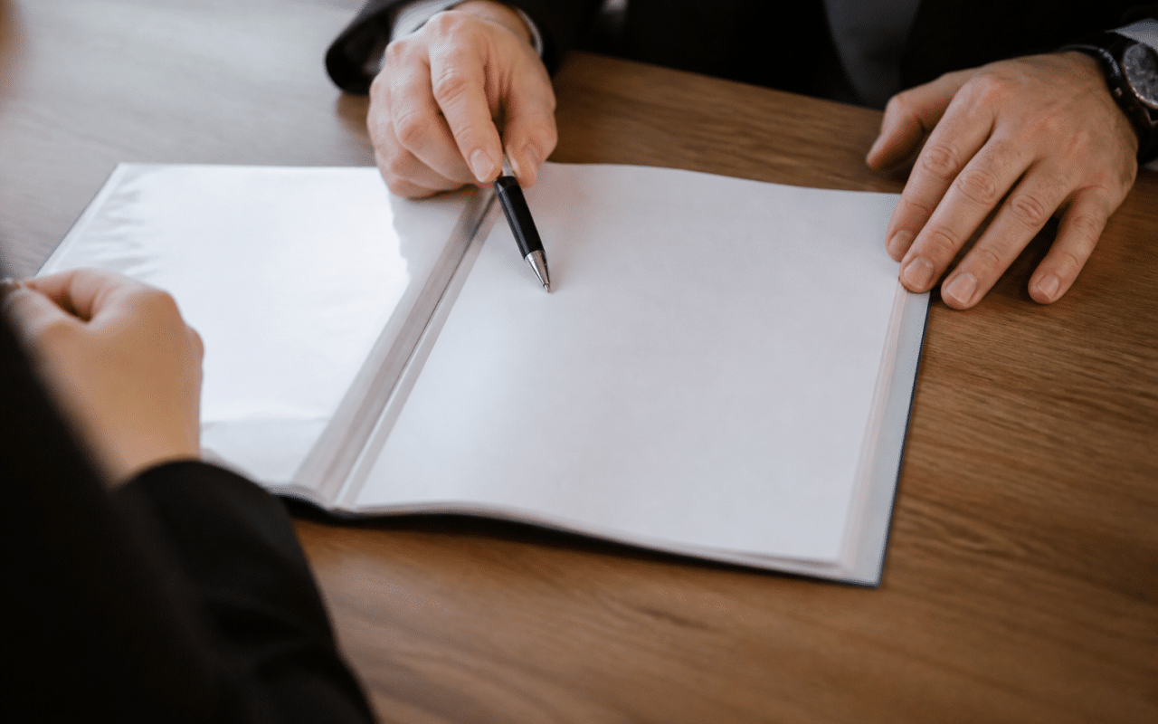 Document d'assurance vie ouvert sur bureau avec stylo pointant vers beneficiaire
