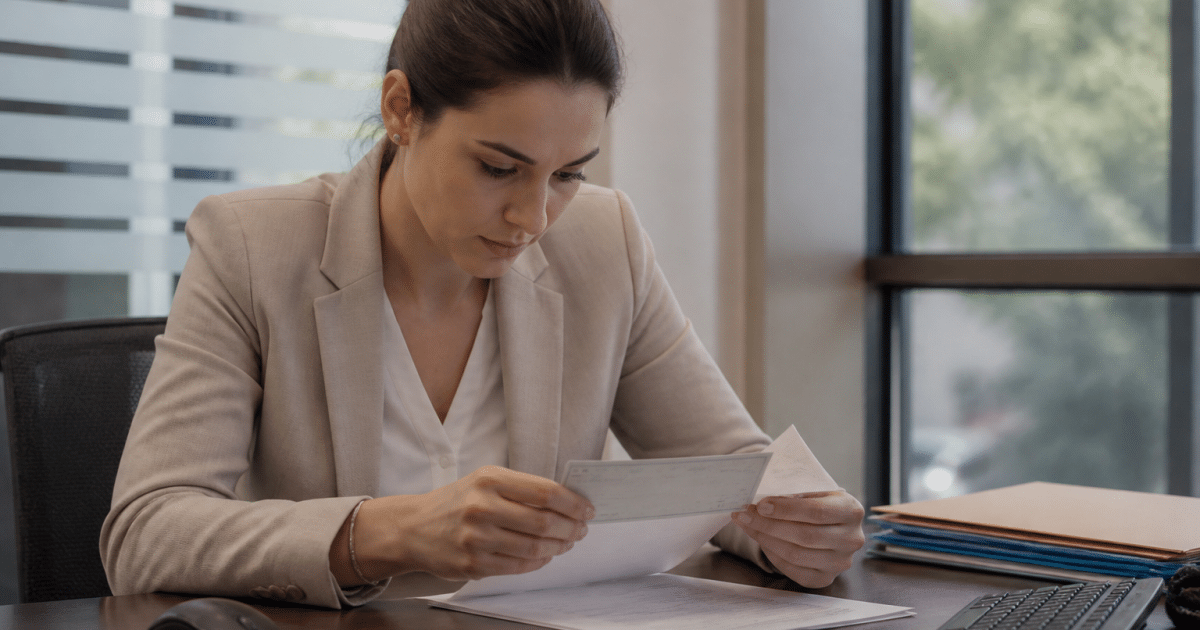 Employe bancaire verifie cheque montant sur document papier