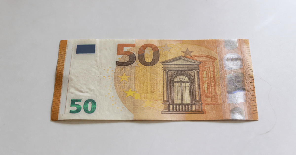 Billet de cinquante euros pose horizontalement sur surface blanche