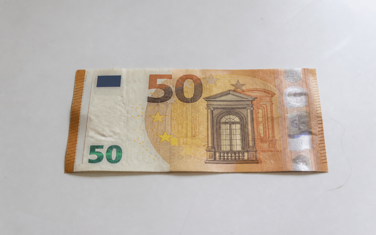 Billet de cinquante euros pose horizontalement sur surface blanche