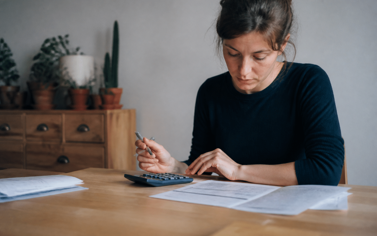 Personne consultant document commercial avec calculatrice et stylo