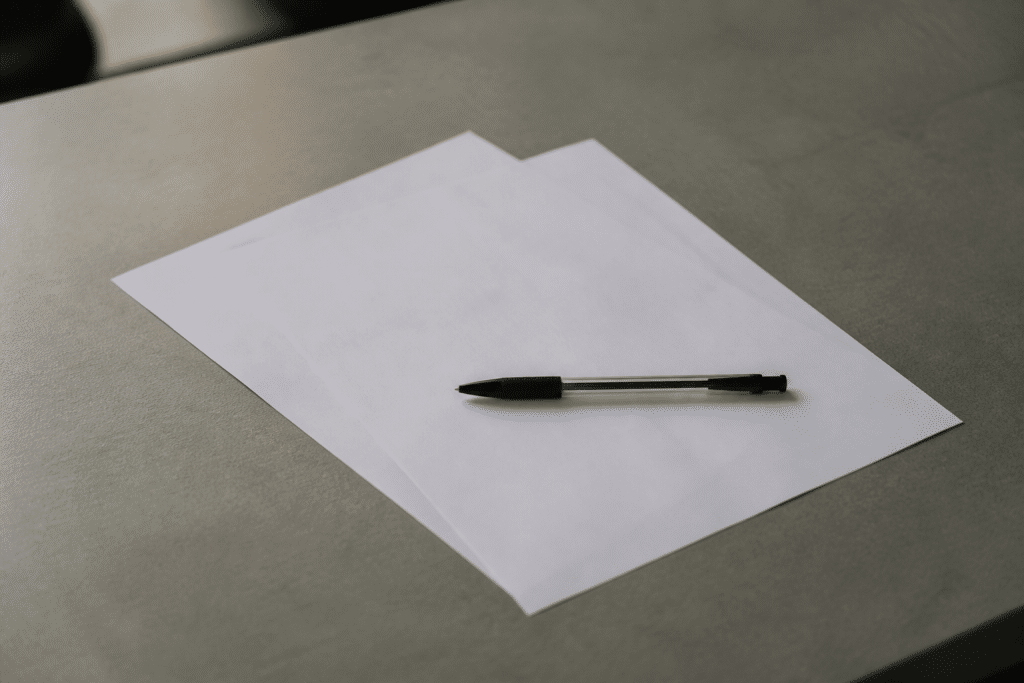 Deux documents papier avec stylo sur bureau gris