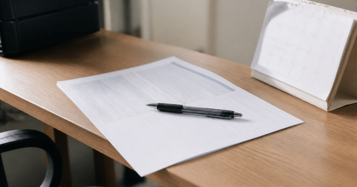 Formulaire administratif posé sur bureau avec stylo et calendrier