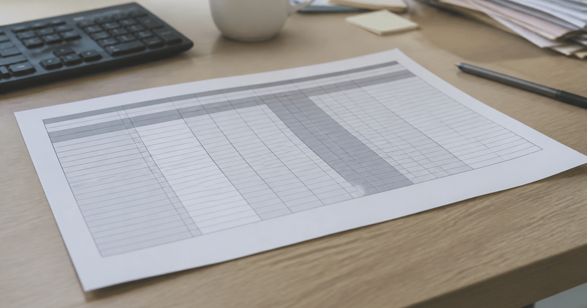 Document papier affichant barèmes salaires sur bureau professionnel.