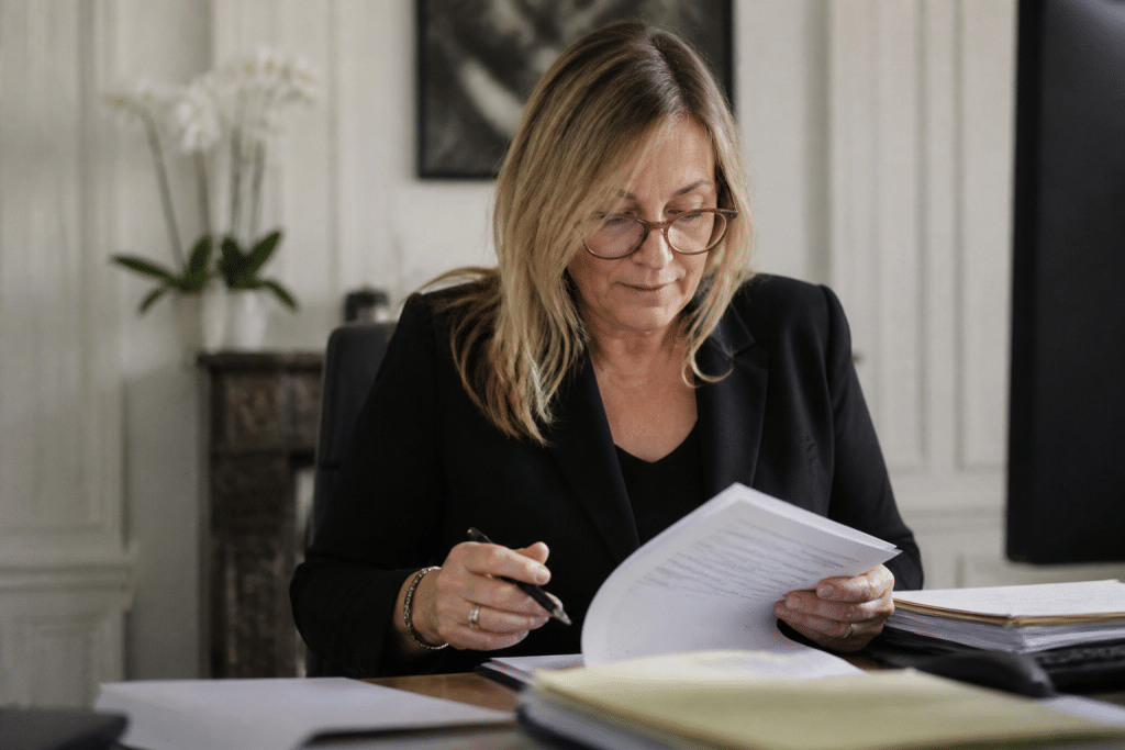 Notaire examinant documents immobiliers avec stylo noir
