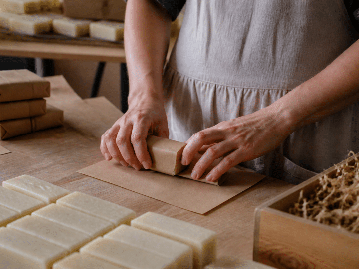 Mains emballant barres de savon sur table de travail