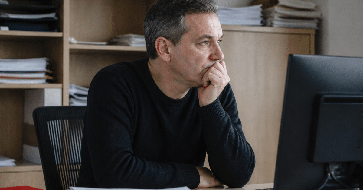 Employé assis attendant documents de paie sur bureau
