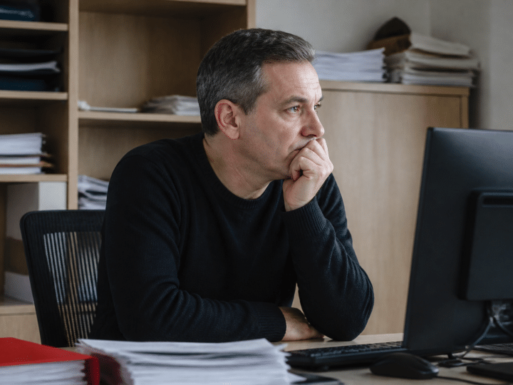 Employé assis attendant documents de paie sur bureau