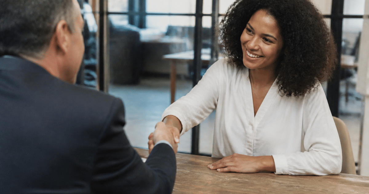 Employeur signant un contrat permanent avec un candidat souriant
