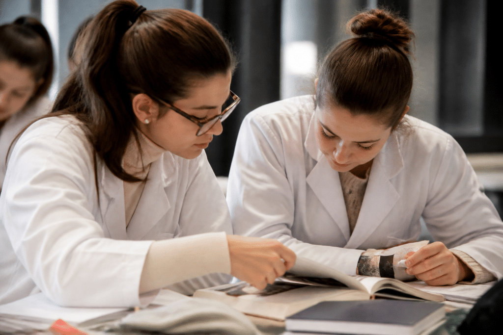 Etudiants en blouse blanche consultant des documents medicaux.