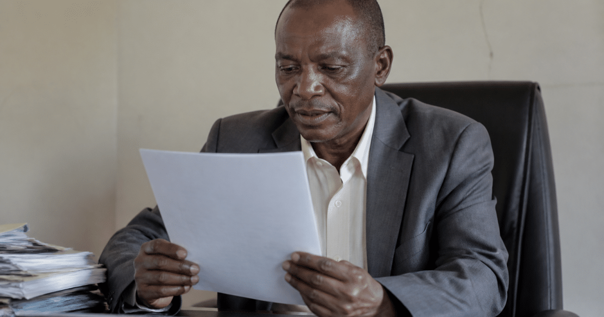 Fonctionnaire tenant un document officiel au bureau assis