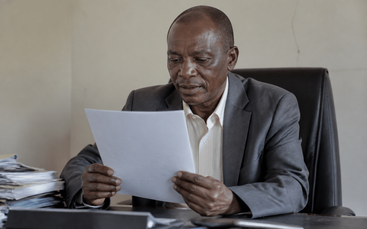 Fonctionnaire tenant un document officiel au bureau assis