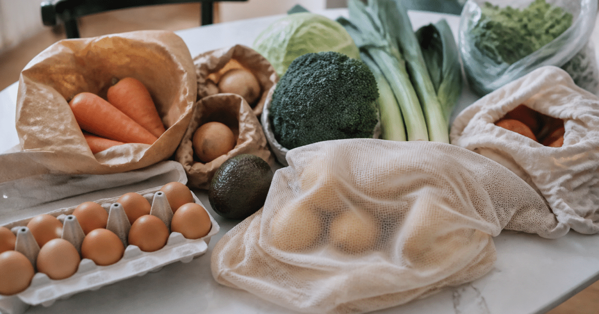 Ingredients et provisions alimentaires disposees sur table blanche.