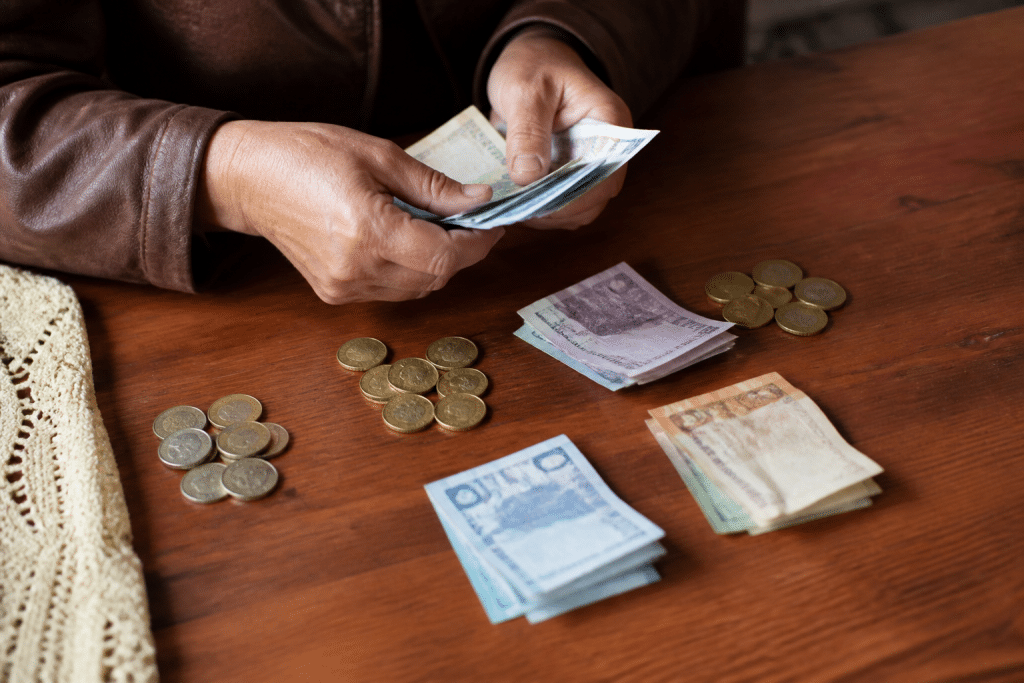 Mains comptant des billets et pièces de monnaie divisées en parts