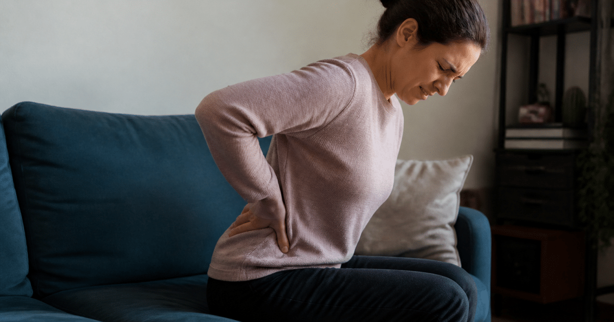 Personne assise tenant son bas du dos douloureux