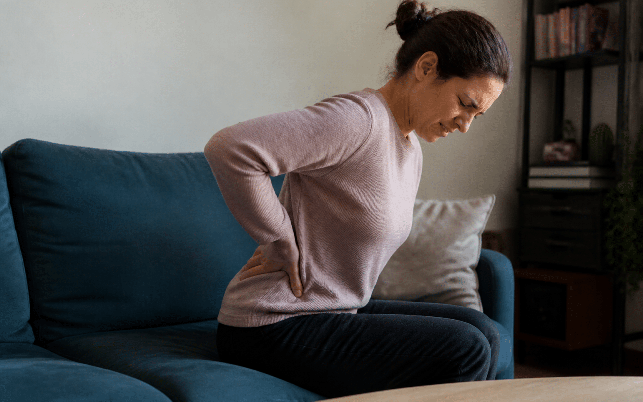 Personne assise tenant son bas du dos douloureux