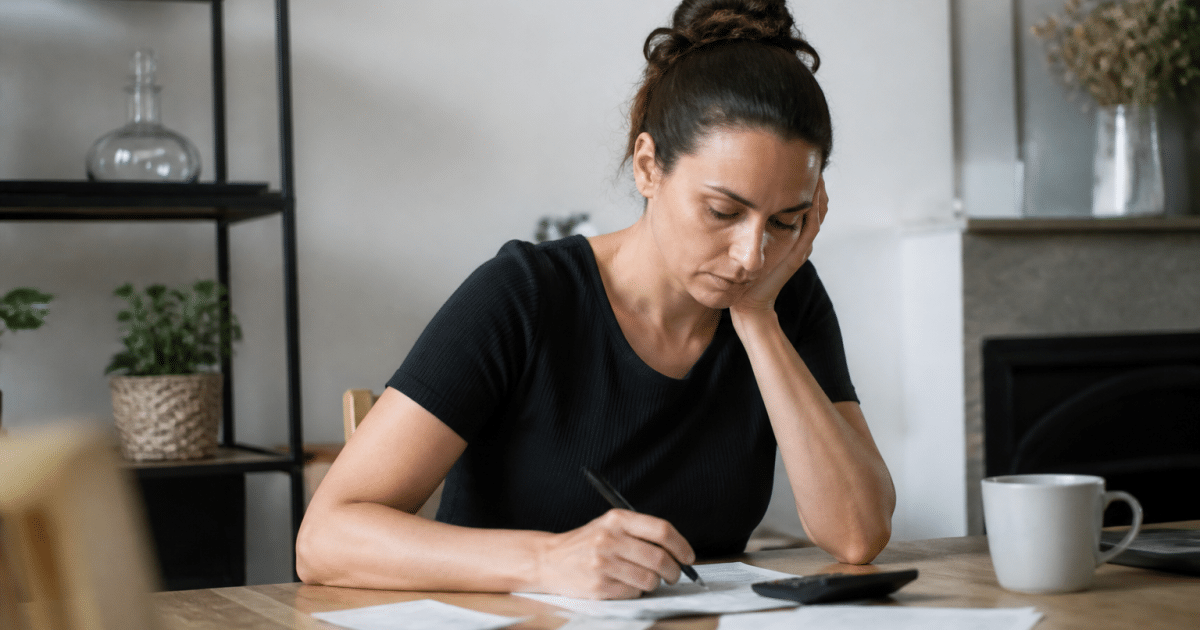 Personne seule assise a table calculant budget allocation logement