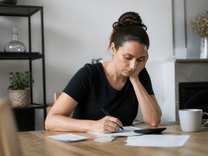 Personne seule assise a table calculant budget allocation logement