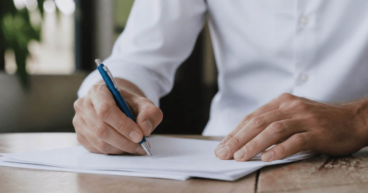 Personne signant un document commercial avec stylo bleu