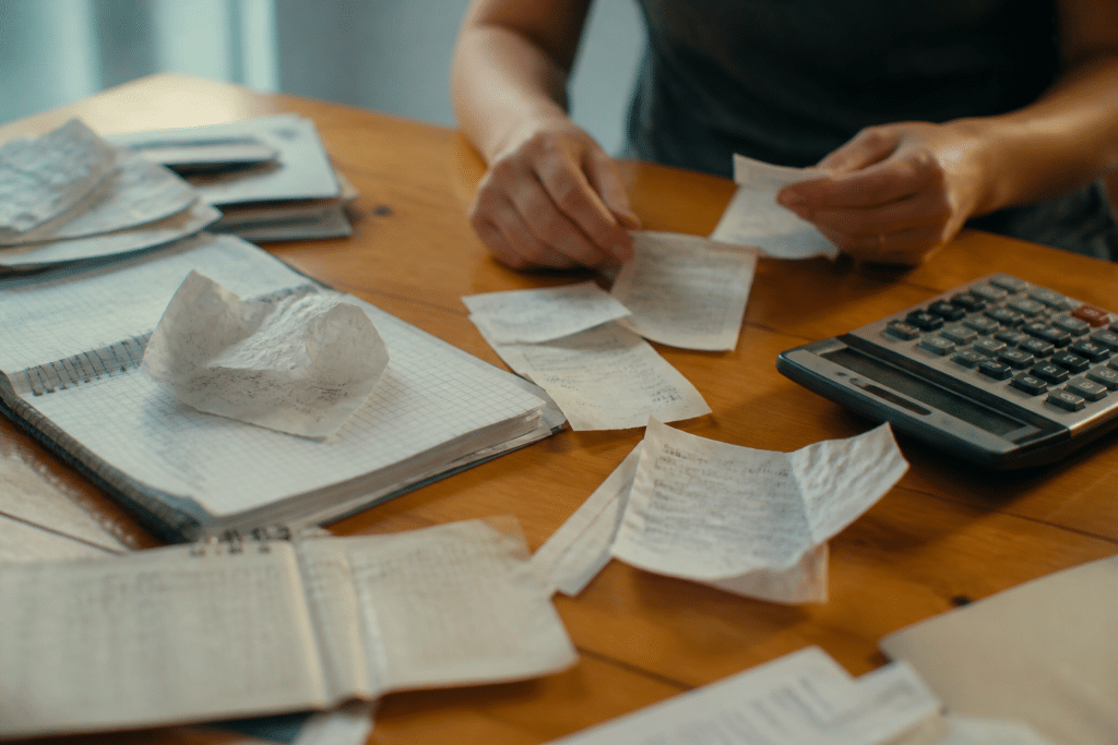 Recettes, tickets de caisse et calculatrice sur table.