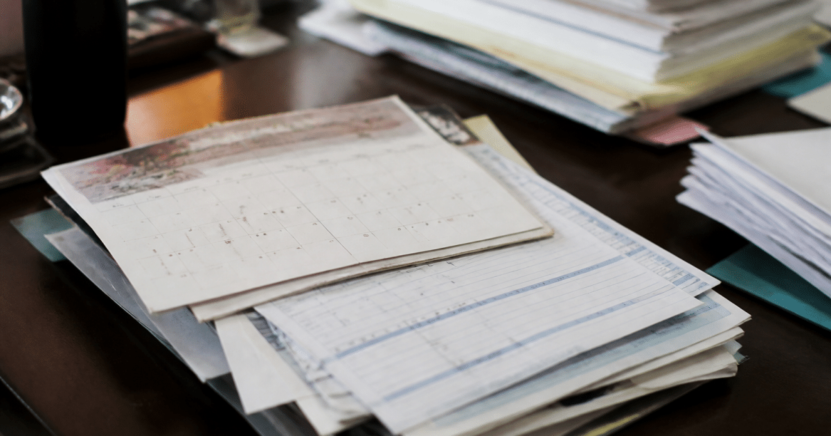 Documents administratifs empilés montrant calendrier et bulletins de paie hospitaliers
