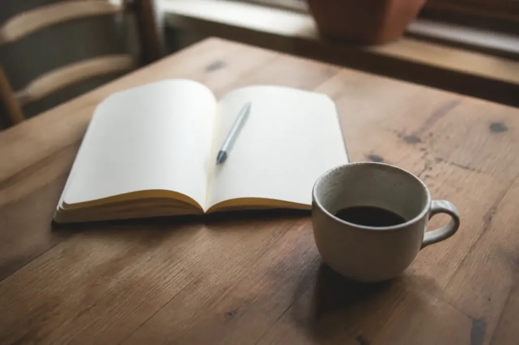Carnet ouvert, stylo et tasse de cafe sur bureau