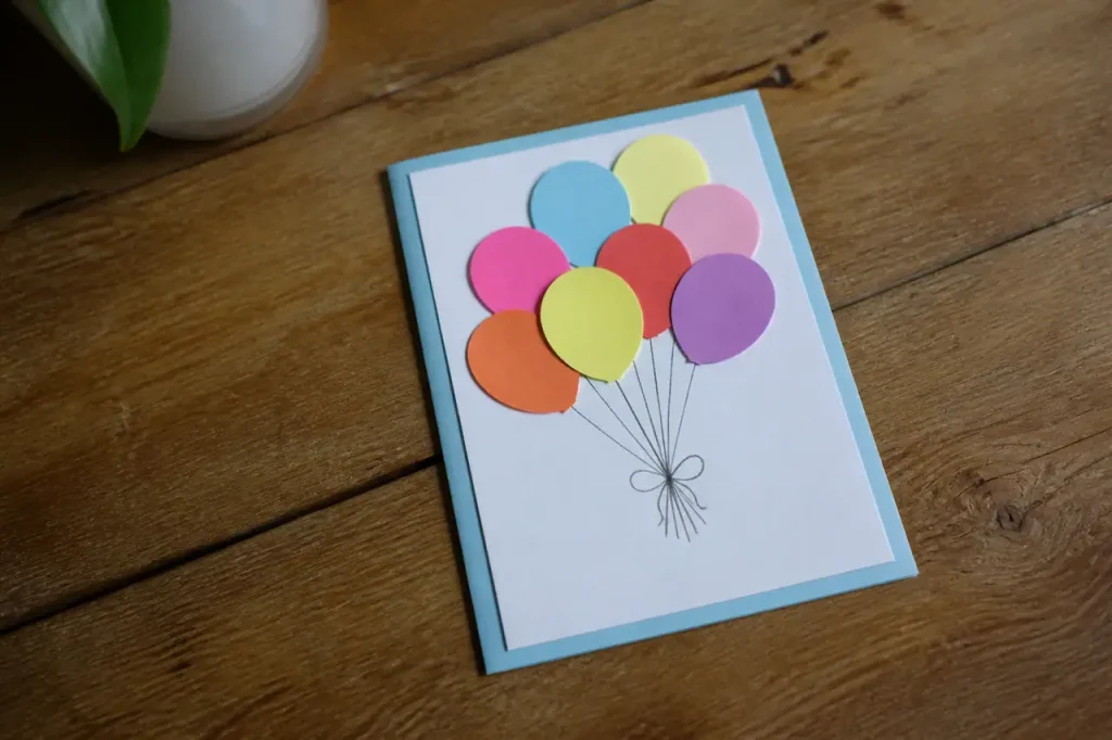 Carte manuscrite ornee de ballons sur table en bois