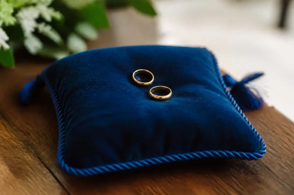 Deux alliances dorees sur coussin de velours bleu