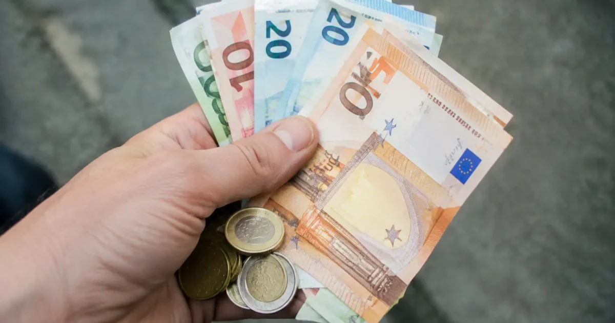 Main posee sur billets et pieces en euros