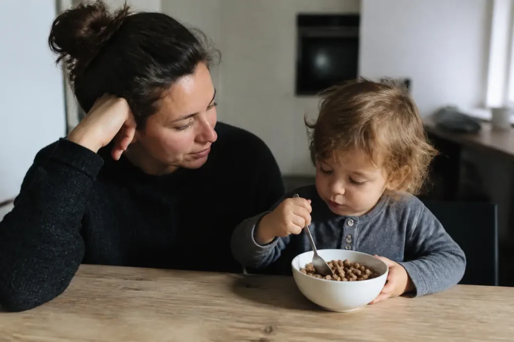 Mere seule et enfant devant un bol de cereales