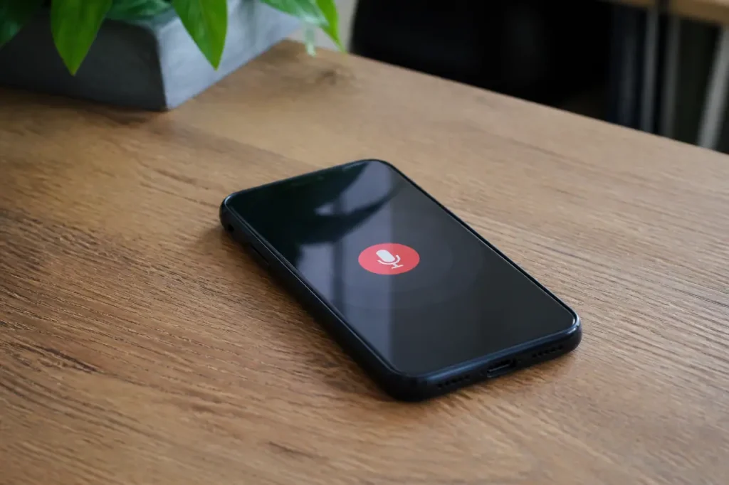 Smartphone pose sur un bureau, icone micro rouge
