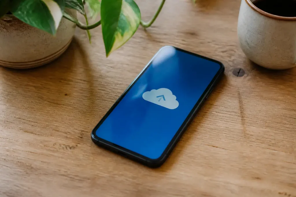 Smartphone pose sur table affichant icone de sauvegarde cloud